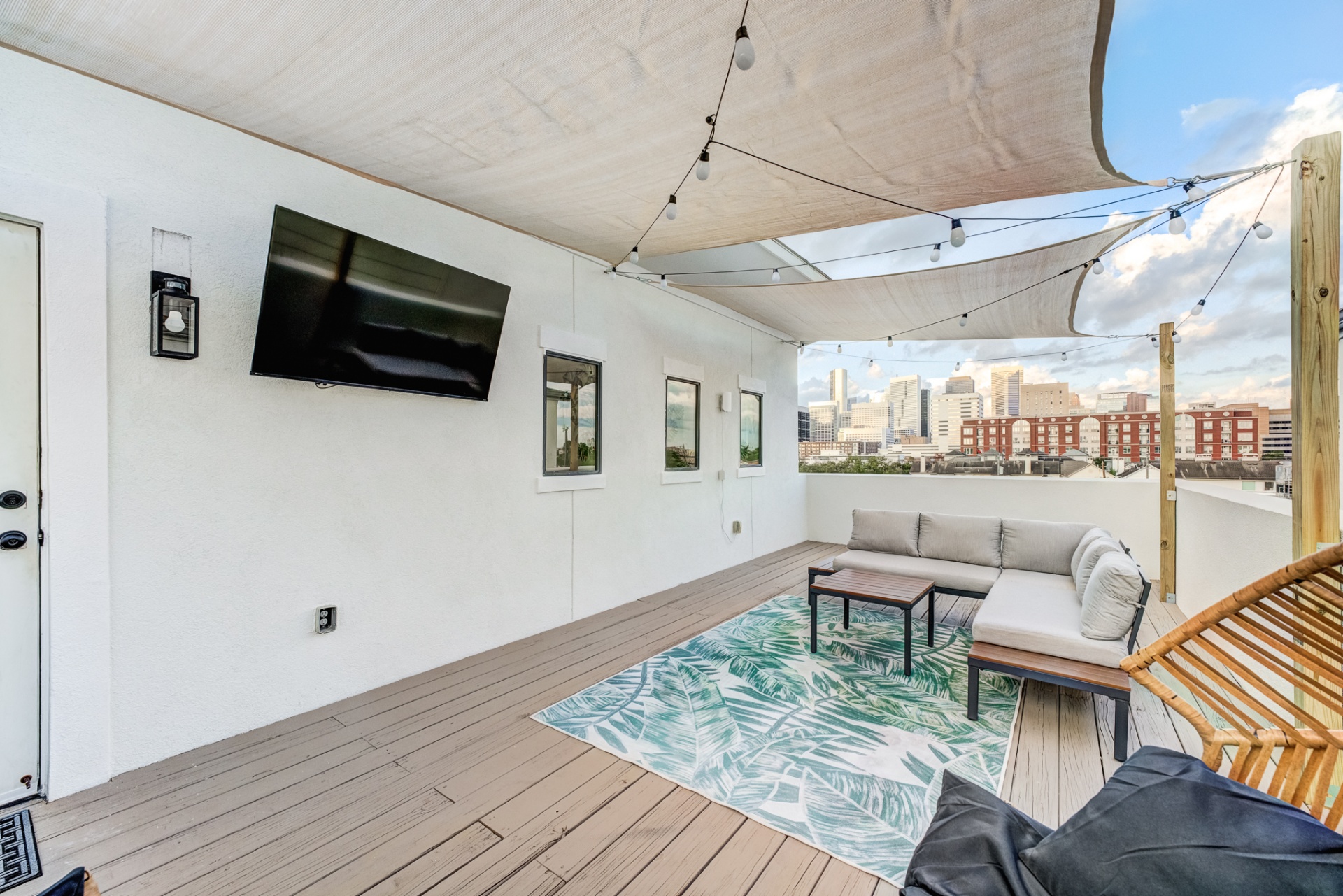 Rooftop lounge with sectional, outdoor TV, and skyline view